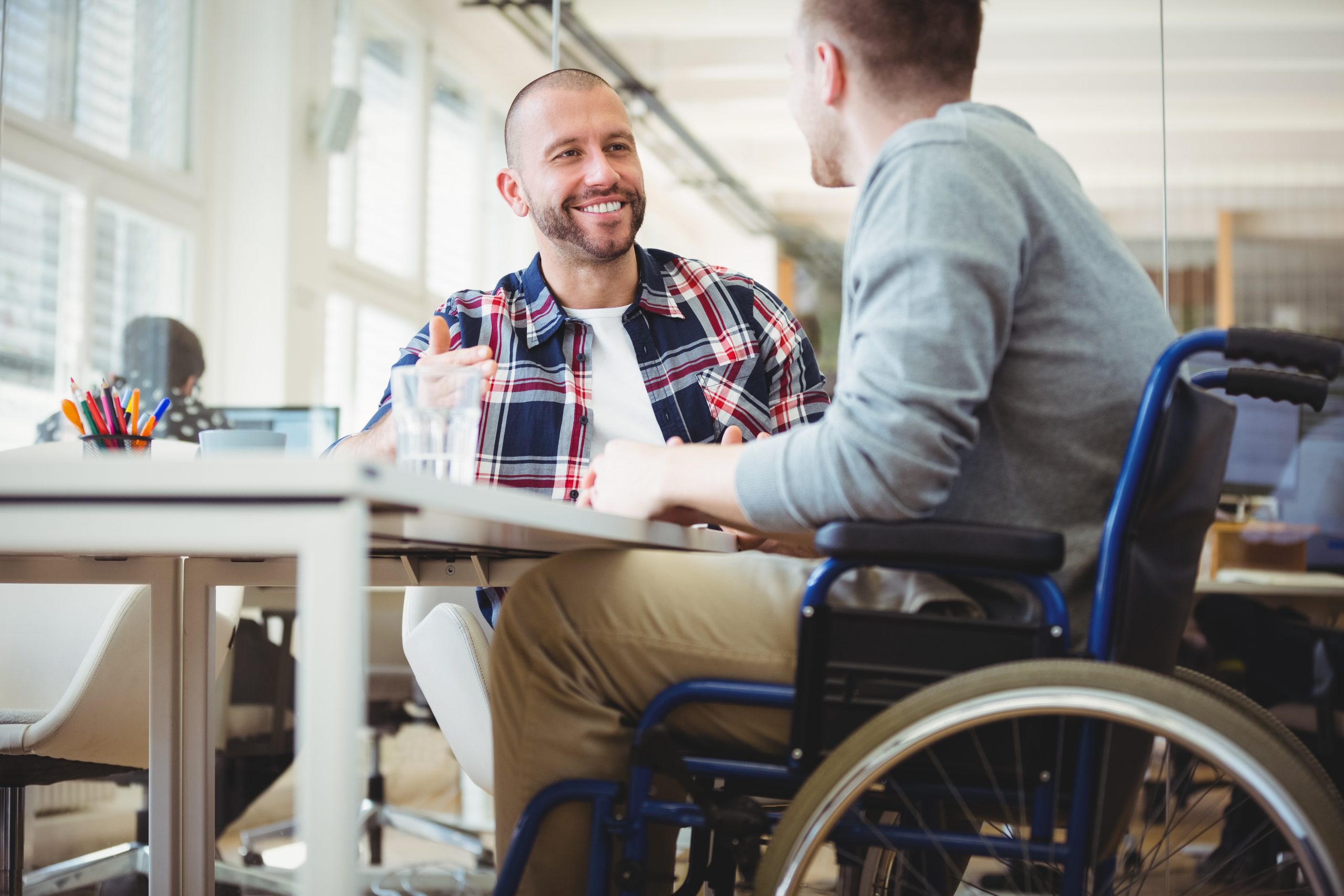 Handicap businessman sitting with colleague in office